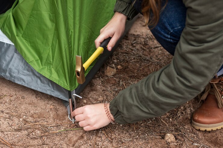 Photo Gratis close-up woman putting up a tent