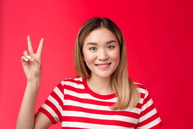 Closeup alegre alegre joven atractiva mujer rubia usar camiseta a rayas sonriendo amistoso hacer orden r ...