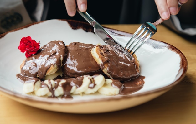 Foto gratuita closeup deliciosos panqueques con chocolate y plátano para el desayuno