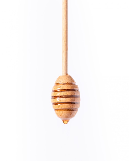 Closeup foto de una cuchara de madera de miel aislada