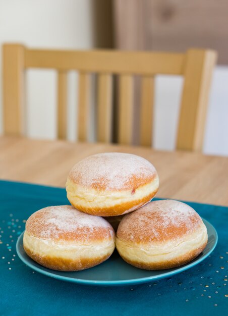 Closeup foto de donas dulces frescas en una placa azul.