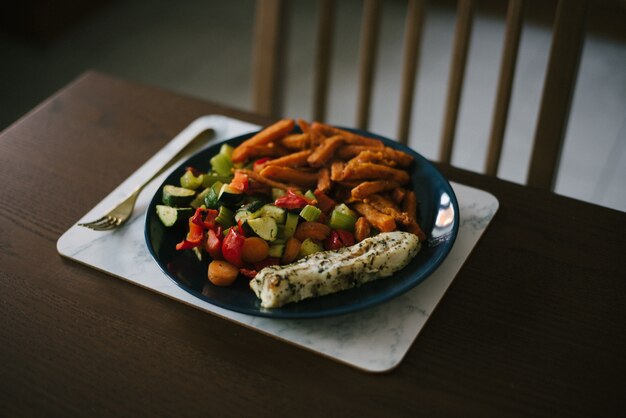 Closeup foto de una ensalada de verduras y papas cortadas en julianas finas sobre la mesa de madera