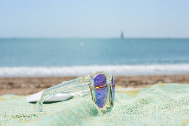 Closeup foto de funky gafas de sol en la toalla de playa en una playa de arena