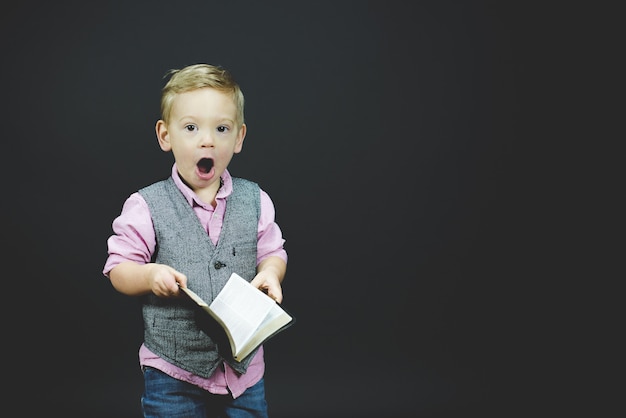 Closeup foto de un niño sorprendido sosteniendo la Biblia