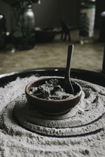 Closeup foto de una olla de cerámica con ingredientes y una cuchara con harina alrededor