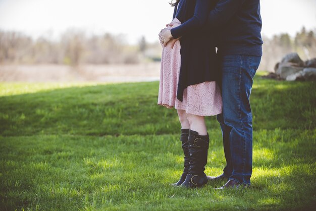 Closeup foto de una pareja embarazada de pie en un campo de hierba