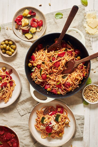 Closeup foto de pasta con verduras e ingredientes sobre una mesa blanca