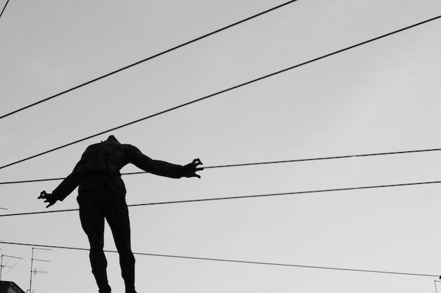 Closeup foto de una silueta de una persona en el aire con cables que van detrás del cuerpo