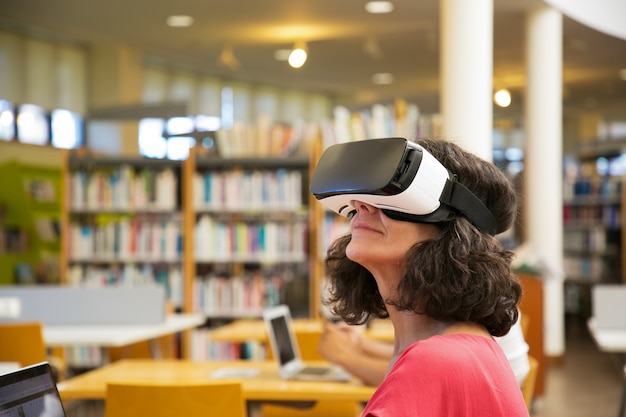 Closeup foto de sonriente mujer caucásica con auriculares VR