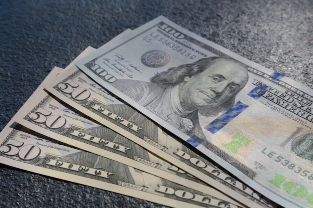 Closeup foto de tres billetes de cincuenta y cien dólares