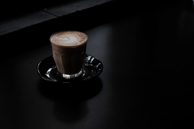 Closeup foto de un vaso de café sobre una superficie negra