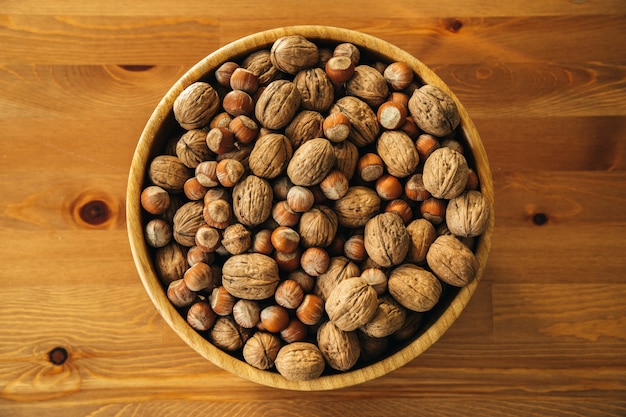 Closeup fotografía cenital de nueces en una placa de madera sobre una mesa de madera