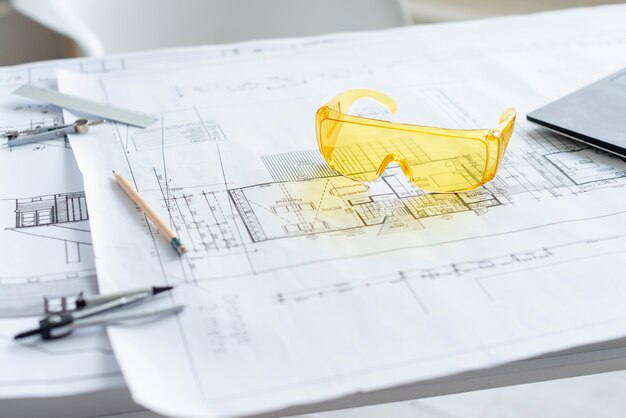 Closeup gafas de seguridad amarillas en proyecto arquitectónico