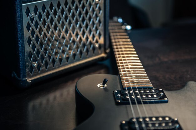 Closeup guitarra eléctrica negra sobre un fondo oscuro