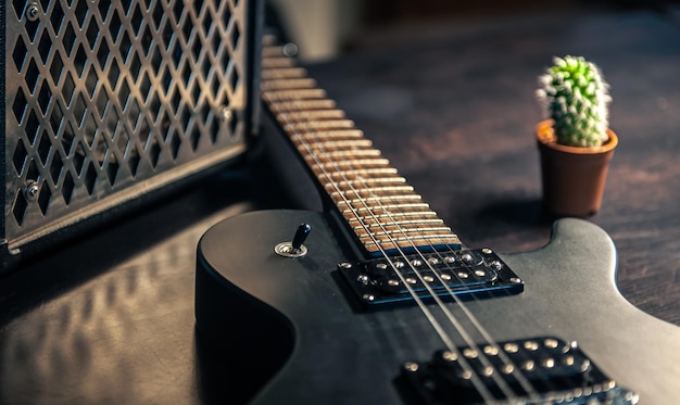 Closeup guitarra eléctrica negra sobre un fondo oscuro