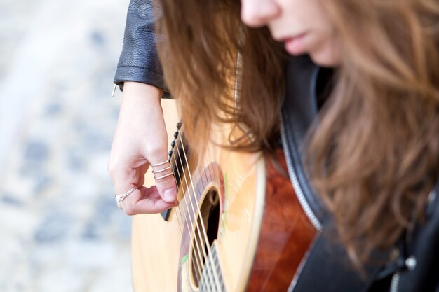 Closeup imagen de mujer joven tocando la guitarra