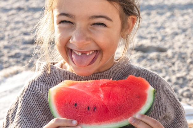 Foto gratuita closeup niña come sandía en la playa