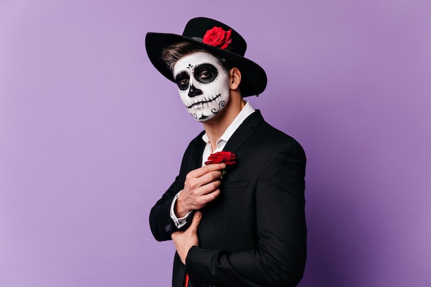 Foto gratuita closeup retrato de chico disfrazado de halloween al estilo mexicano, complementando el atuendo con rosa roja.