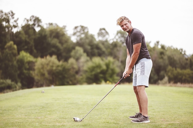 Closeup retrato de enfoque de un joven jugando al golf