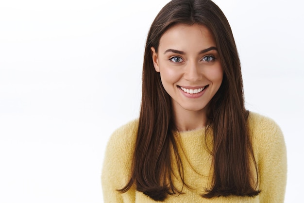 Closeup retrato femenino hermosa joven morena con radiante sonrisa blanca mirando cámara feliz sonriendo concepto de gente hermosa y productos para el cuidado de la piel promo fondo blanco