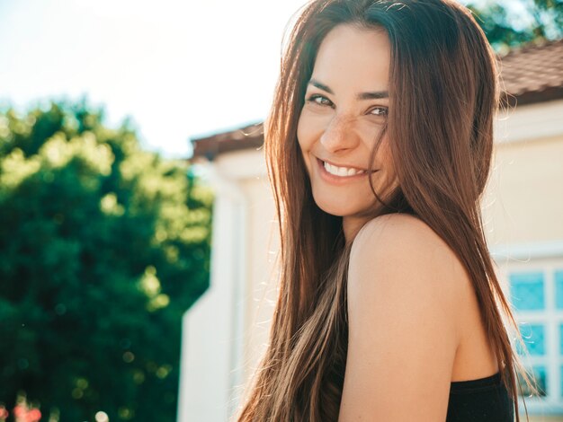 Closeup retrato de hermosa modelo morena sonriente. Mujer de moda posando en la calle