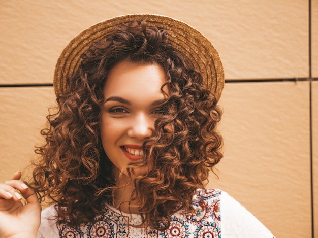 Closeup retrato de hermosa modelo sonriente con peinado afro rizos vestido con vestido blanco hipster de verano.