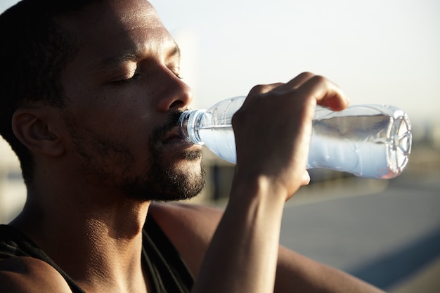 Closeup retrato de joven barbudo agua potable