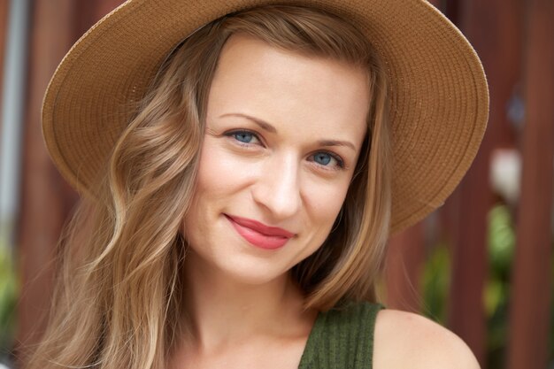 Closeup retrato de una joven mujer chrming en un sombrero de paja