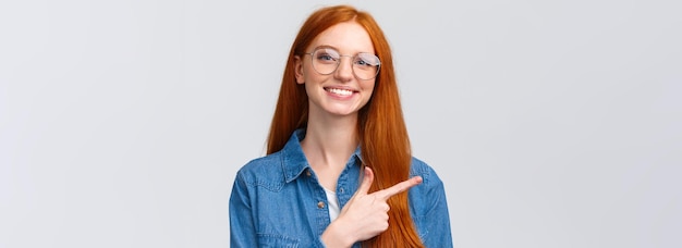 Foto gratuita closeup retrato lindo alegre pelirroja foxy chica en gafas mostrando lugar para hacer clic en el sitio web seguir o