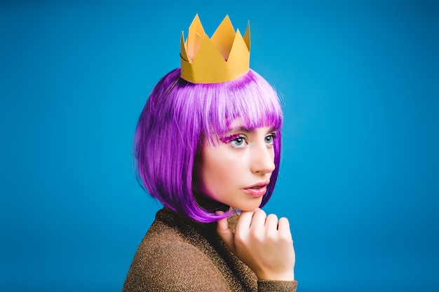 Closeup retrato de moda joven mujer seria en corona de oro. Corta el pelo morado, estilo princesa