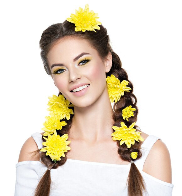 Closeup rostro de una joven hermosa mujer sonriente con maquillaje amarillo brillante Retrato de moda Chica atractiva con coletas de peinado con estilo aislado en blanco Maquillaje profesional