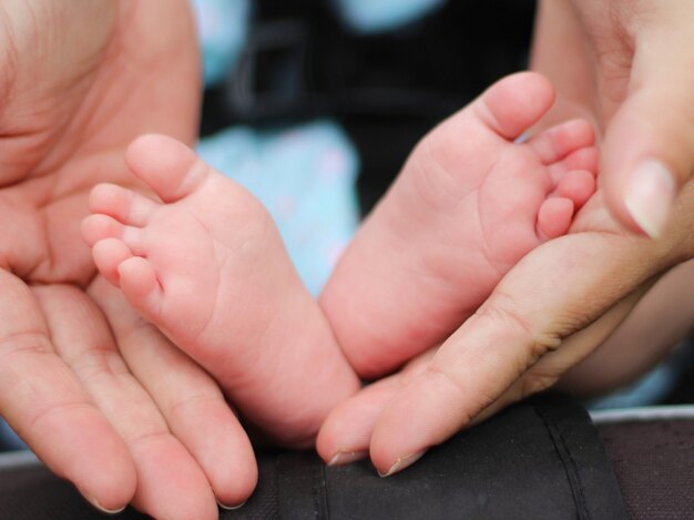 Closeup shot de dedos de los pies del bebé en manos de los padres