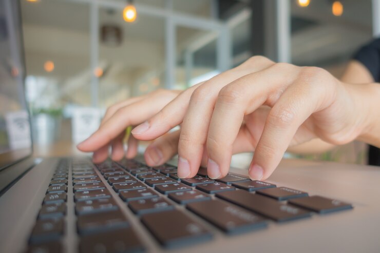 Photo Gratis closeup tangan wanita bisnis mengetik di keyboard laptop.