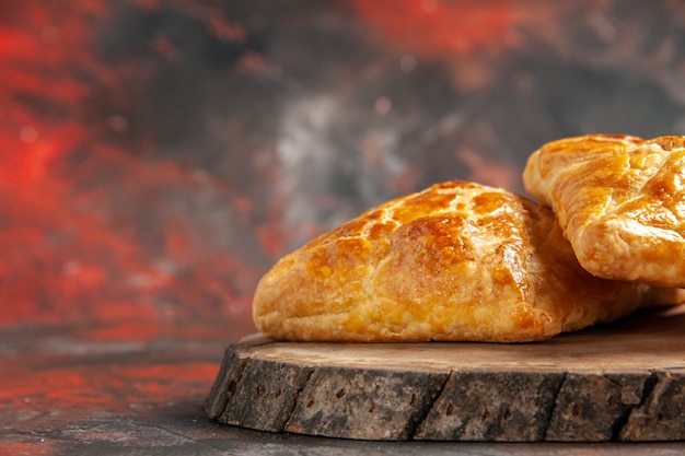 Foto gratuita closeup vista frontal penovani khachapuri sobre tablero de madera en lugar libre de mesa rojo oscuro