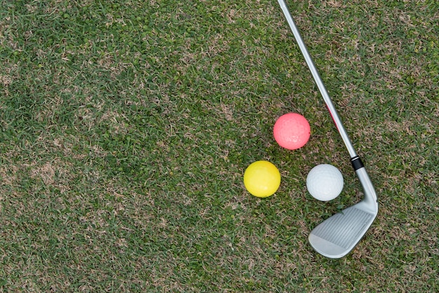 Club de golf y pelotas en curso