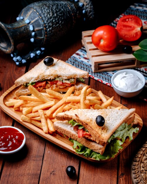 Club sandwich con papas fritas en la mesa