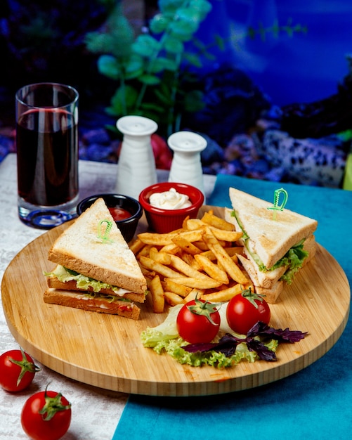 Club sandwich con papas fritas y tomates