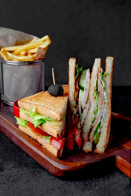 Club sandwich servido con papas fritas