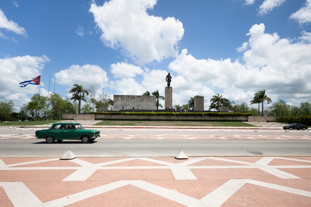 Coche de clasificación pasando frente a monumento en cuba