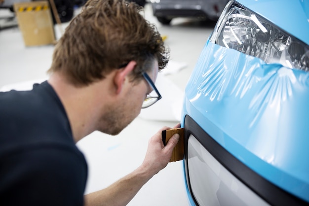 Coche de envoltura profesional de alto ángulo con cubierta azul.