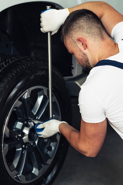 Foto gratuita coche de fijación mecánico masculino de alto ángulo