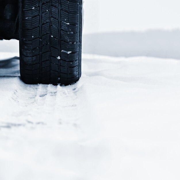 Coche en invierno. Neumático en una carretera nevada con mal tiempo.