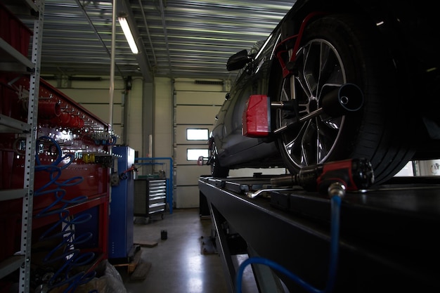 El coche nuevo y brillante en el servicio de automóviles tiene un problema con los neumáticos, que se solucionará pronto.