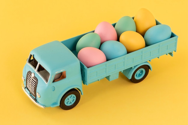 Coche de Pascua con huevos y fondo amarillo.