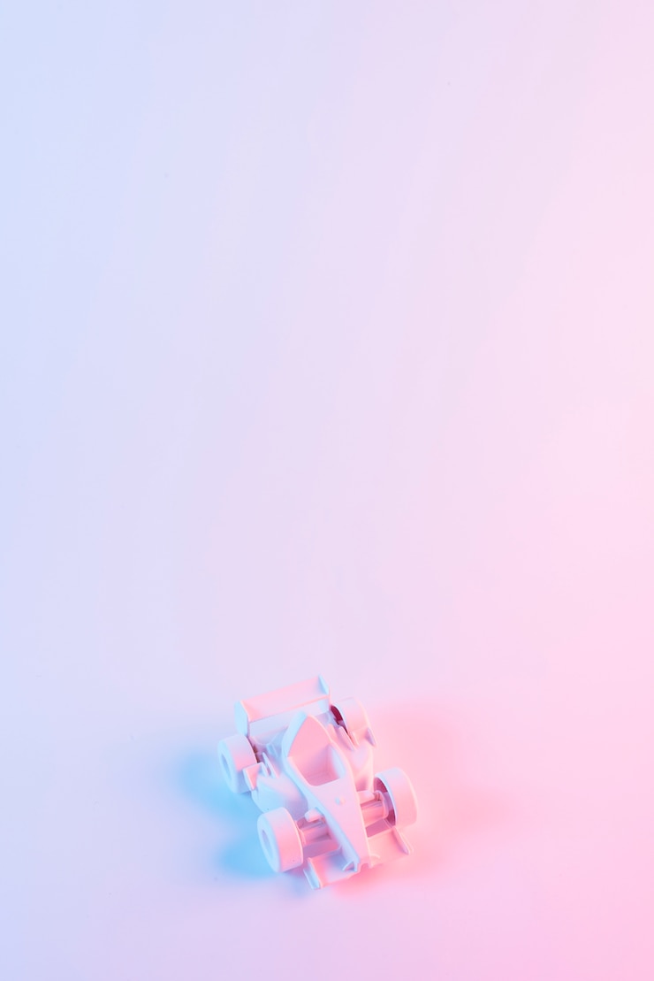 Foto gratuito coche pintado de la fórmula una contra fondo rosado con el copyspace