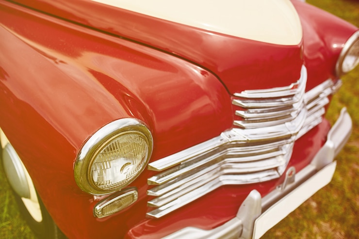 Foto gratuito coche retro estacionado en el césped