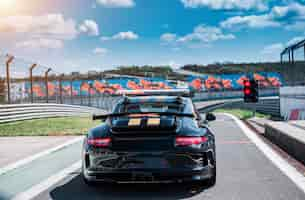 Foto gratuita coche sedán deportivo descapotable negro con dos rayas amarillas,