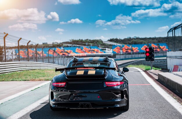 Coche sedán deportivo descapotable negro con dos rayas amarillas,