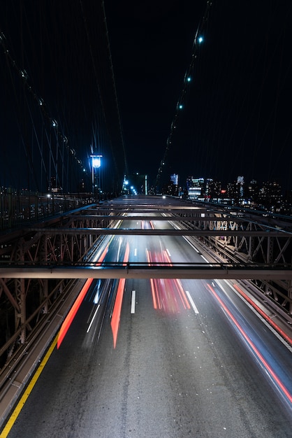 Foto gratuita coches en puente con movimiento borroso en la noche