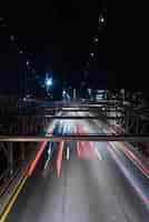 Foto gratuita coches en puente con movimiento borroso en la noche